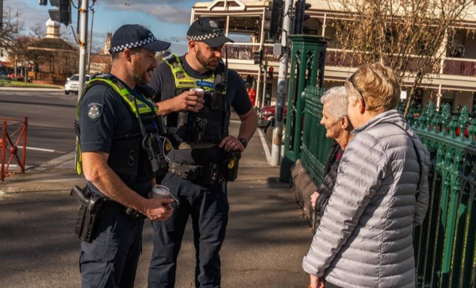 Two police officers talk to two elderly community members.