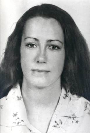Julie Garciacelay, with long hair, and wearing a while collared shirt with a flower pattern.