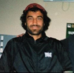 Jamal wearing a black jacket and a red cap.