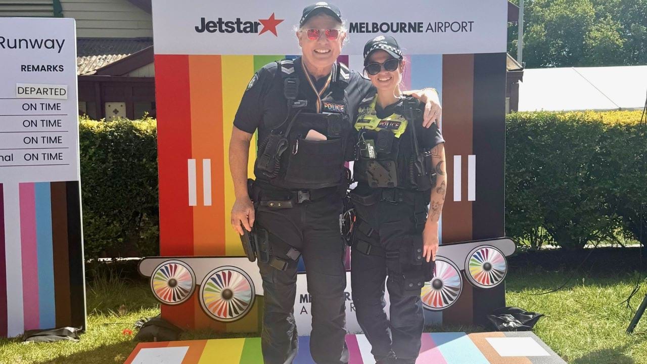 Police officers standing on top of rainbow coloured path