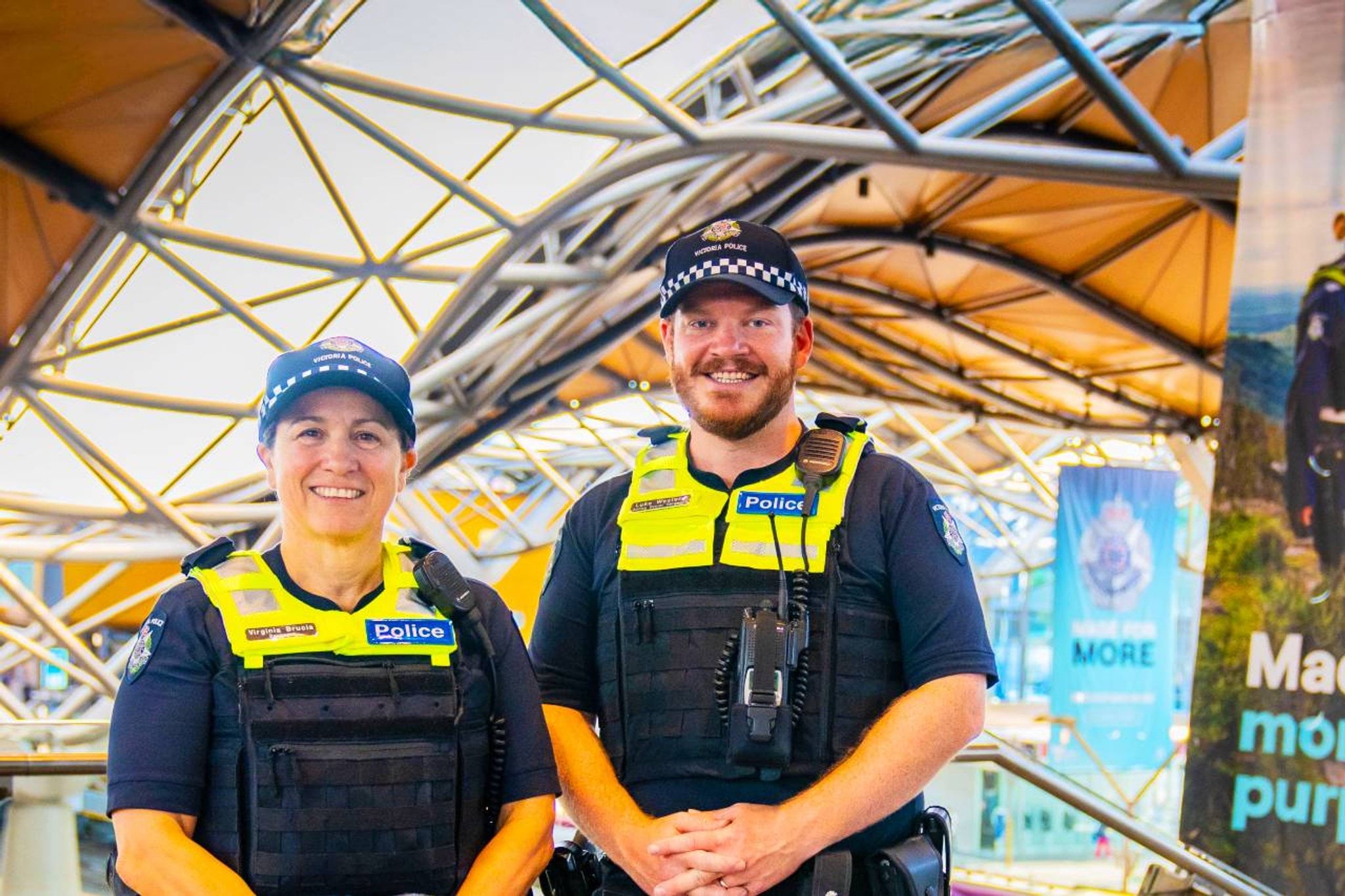 Two smiling officers at a train station