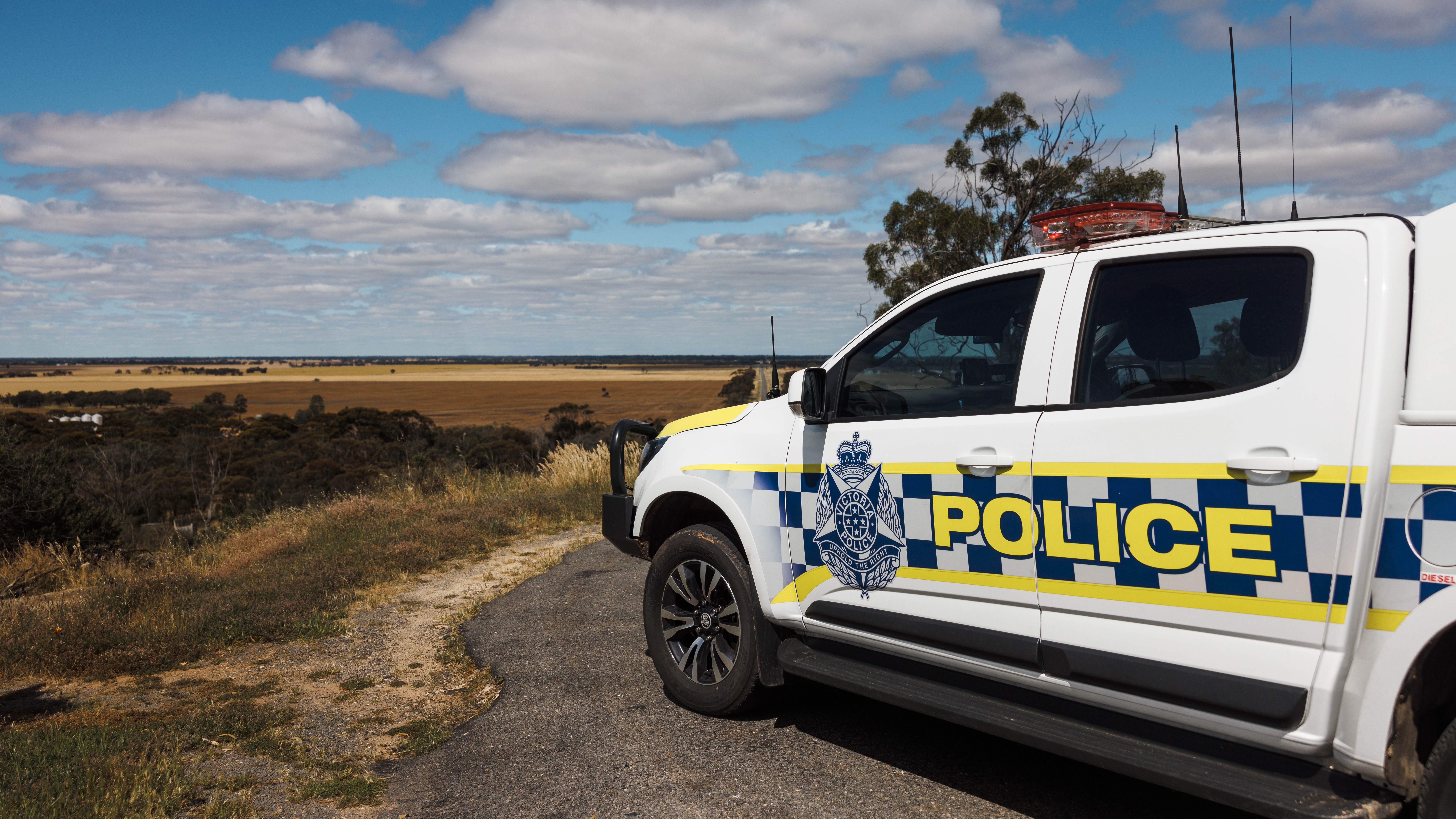 Police Life - image of a police car parked on a rural road. 