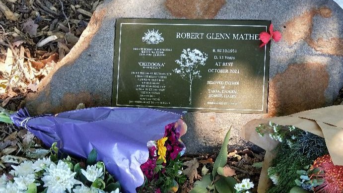 Police Life - image of a gravestone with flowers at it.