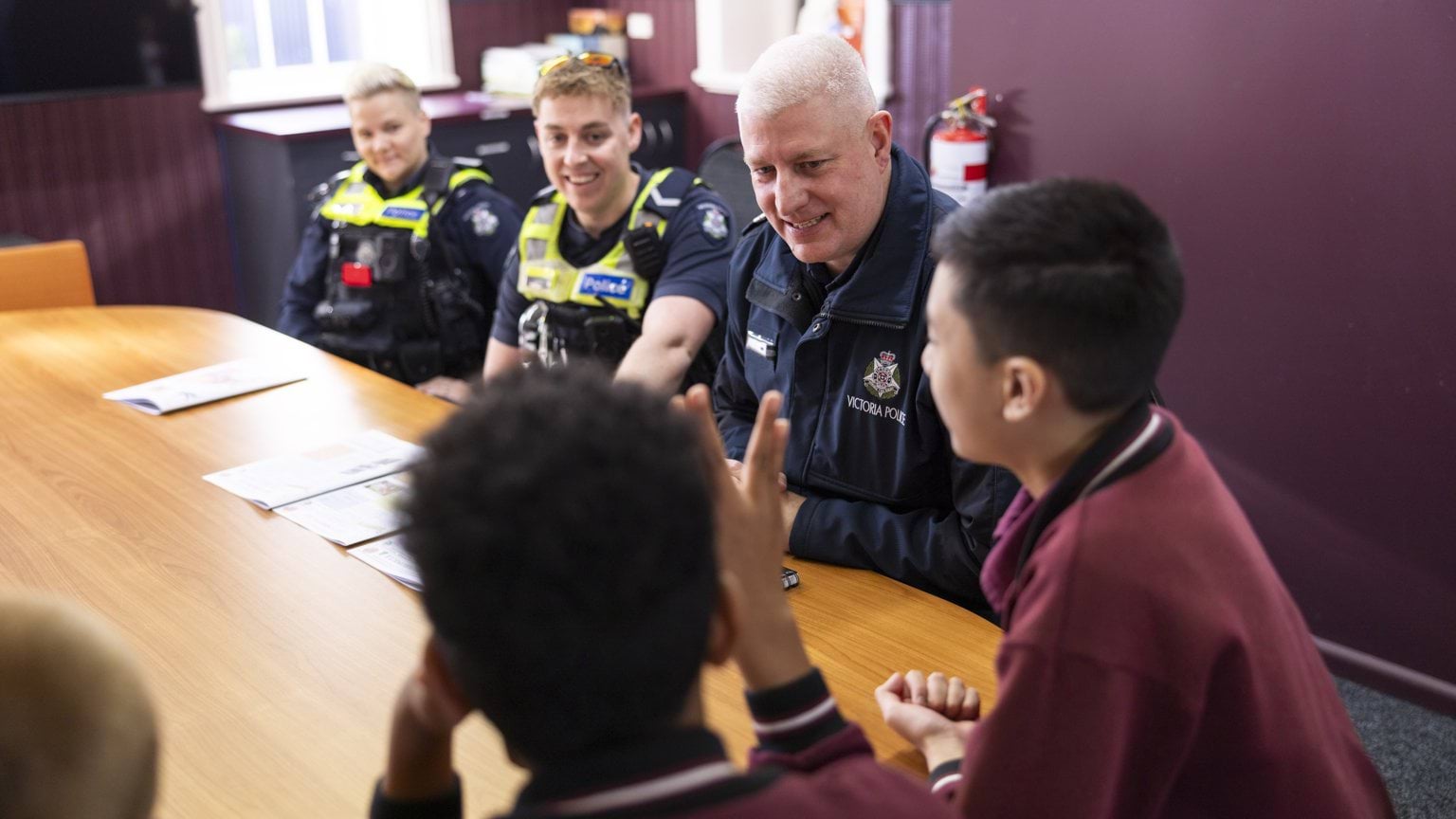 Police Life - a Disability Liaison Officer and two other officers sitting with a group of primary school students