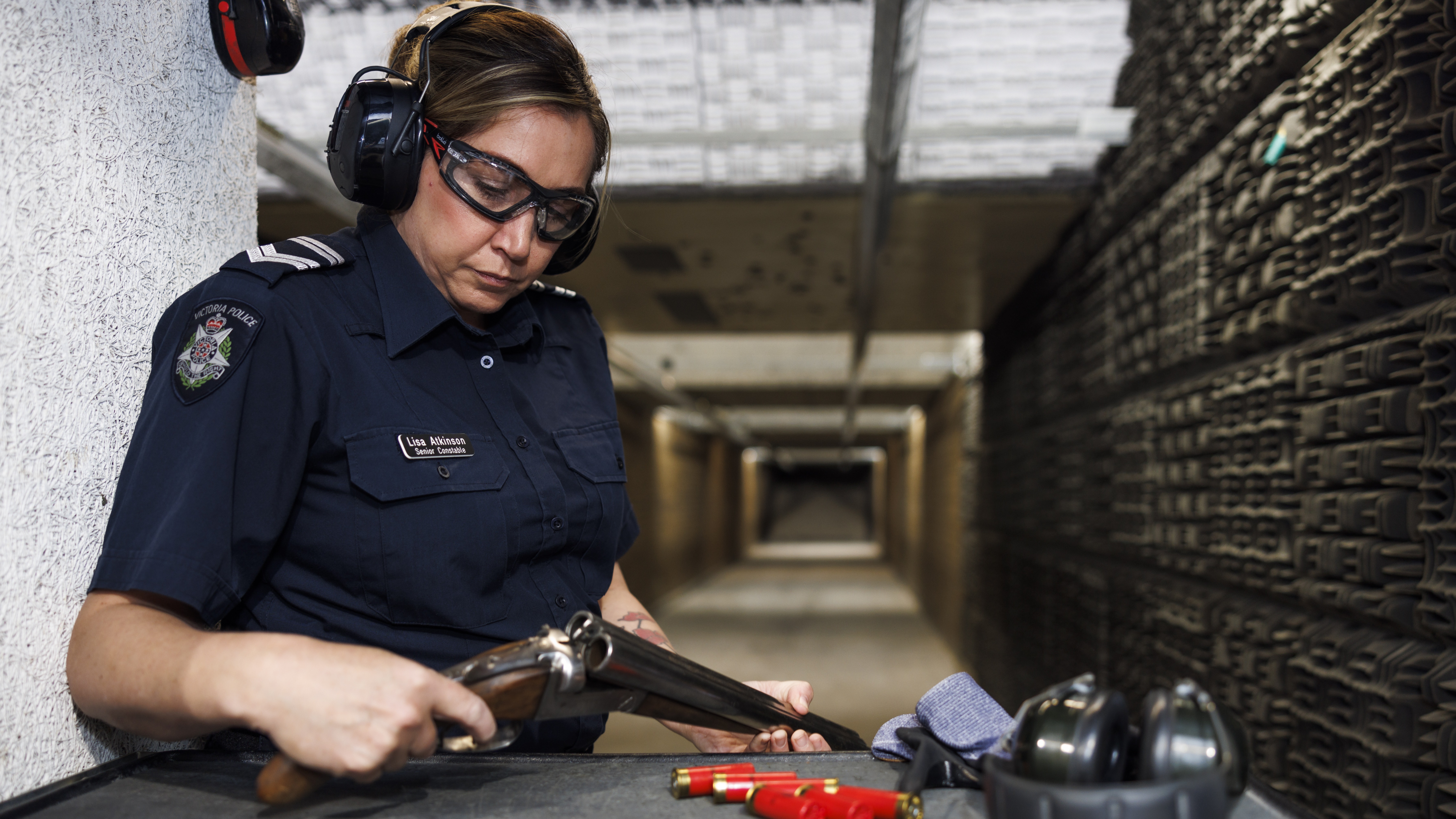Police Life - Female police officer loading gun in shooting range