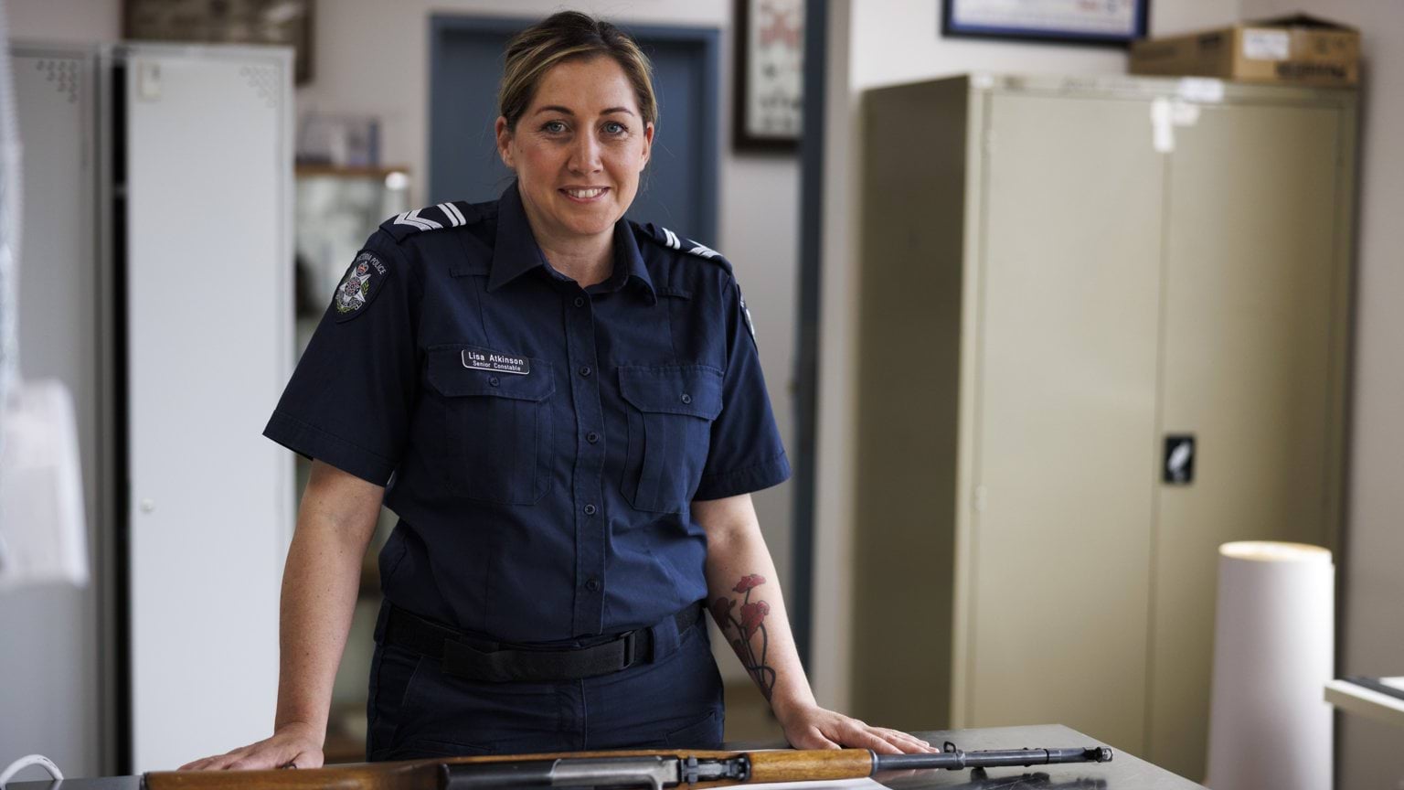 Police Life stories - Taking aim at a new career - Female officer standing in front of gun on a bench - 1280x720 - Feature