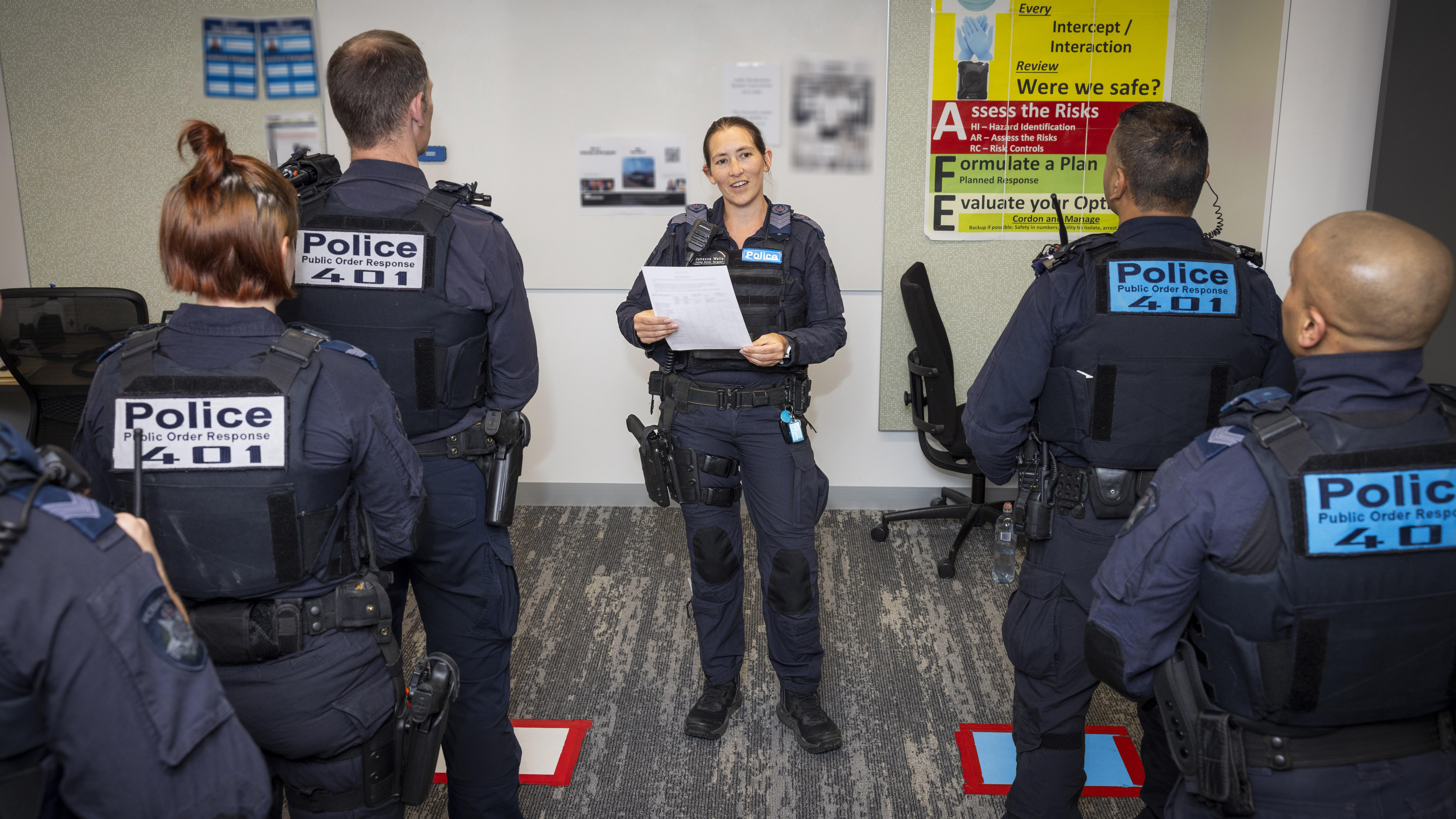 Police Life - A female Public Order Response Team officer briefing a group of other officers
