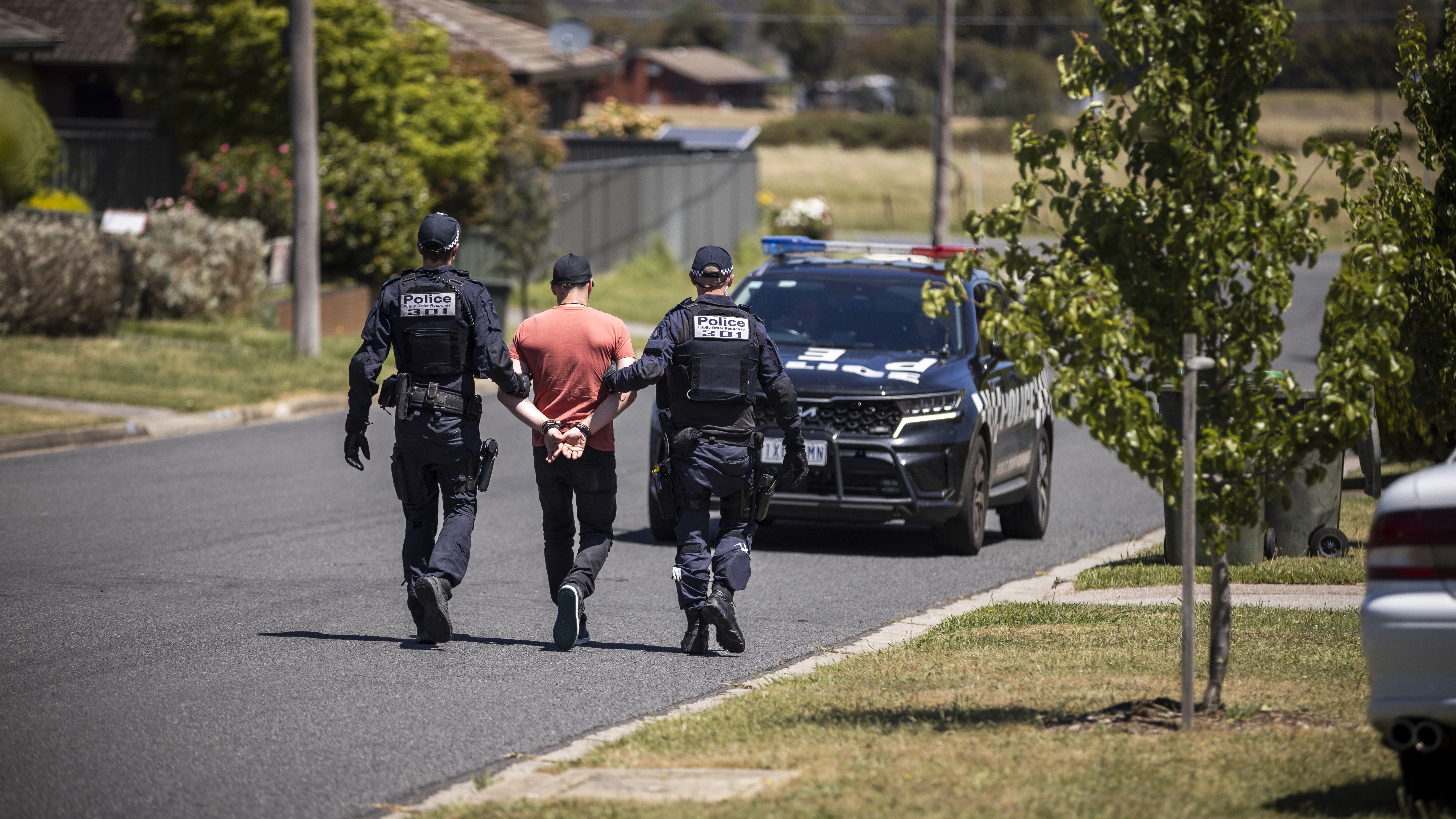 Police Life - two male Public Order Response Team officers arresting a male in a suburban street