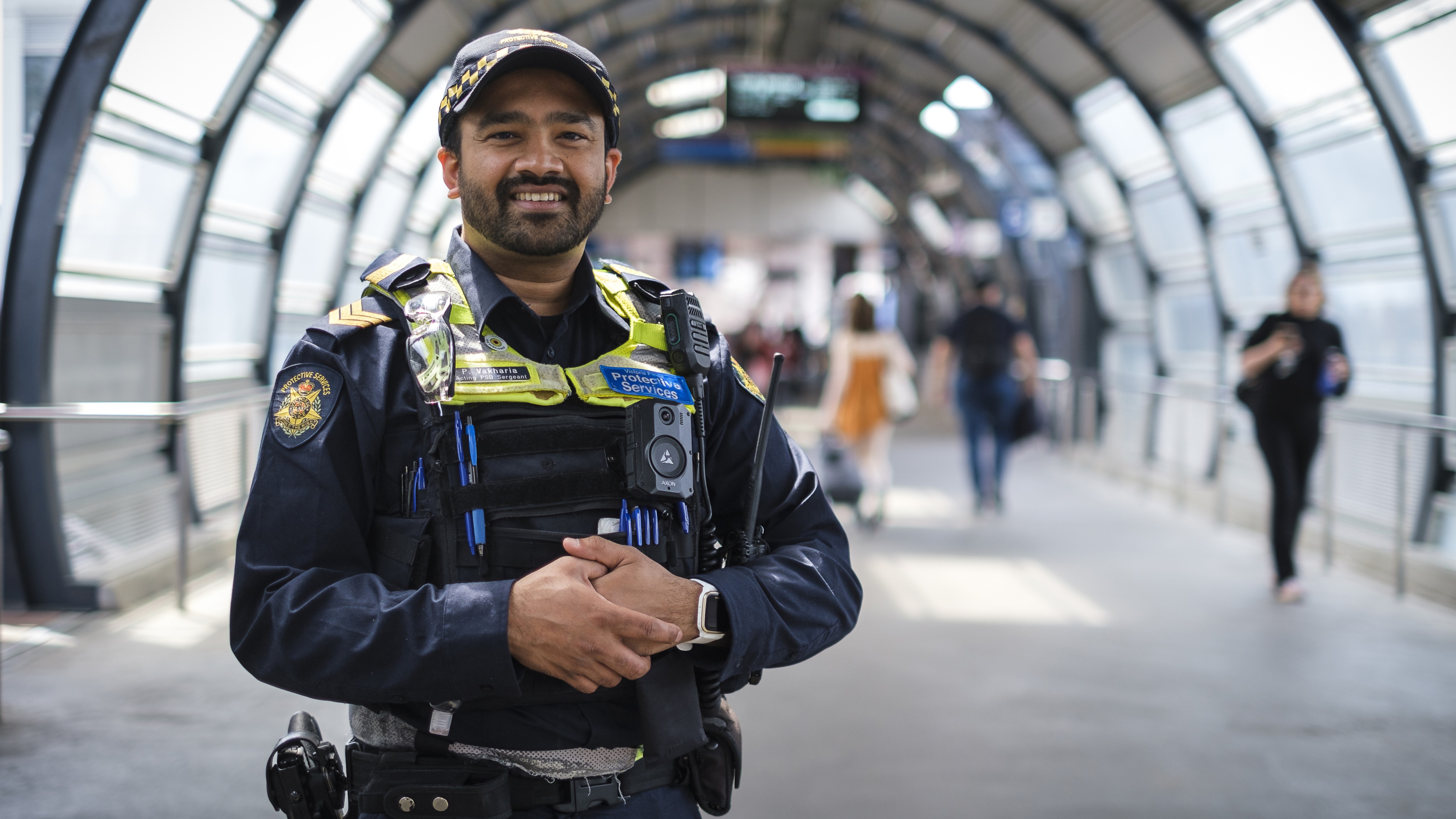 Police Life - Male protective services officer standing in train station corridor