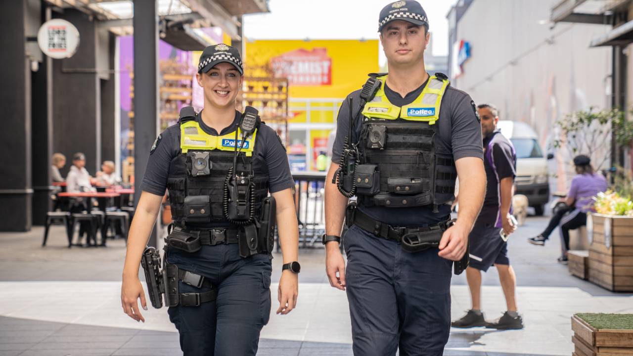 Two police officers smiling and walking in Brunswick