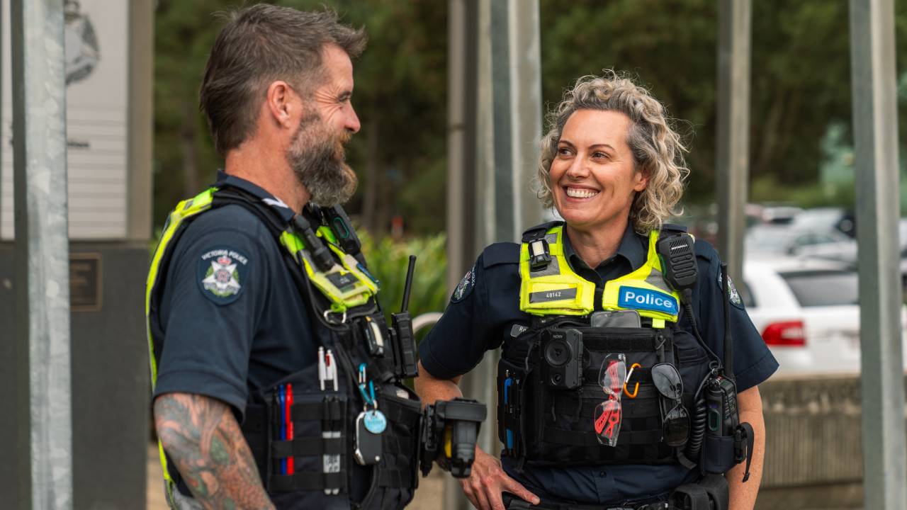 Police officers smiling outside of a police station