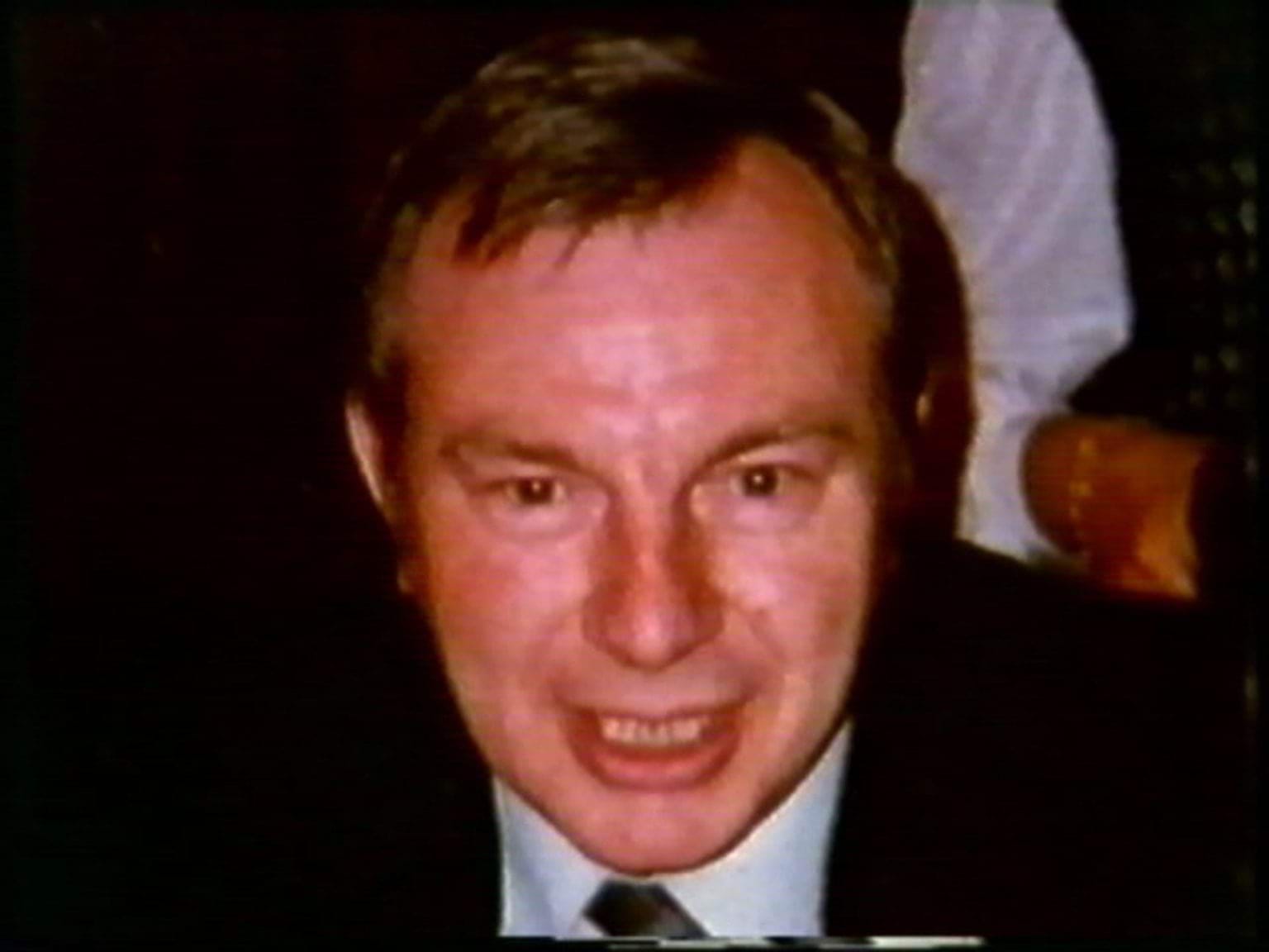 Derek Williams, with short brown hair, wearing a suit and tie with a white shirt.