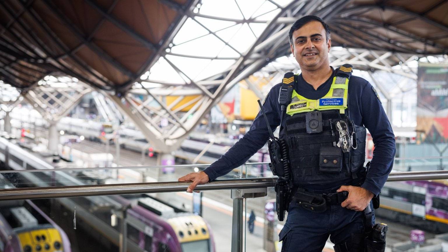 Police Life - PSO Sergeant Kaushal Purohit stands on an elevated platform at Southern Cross train station overlooking the train platforms.
