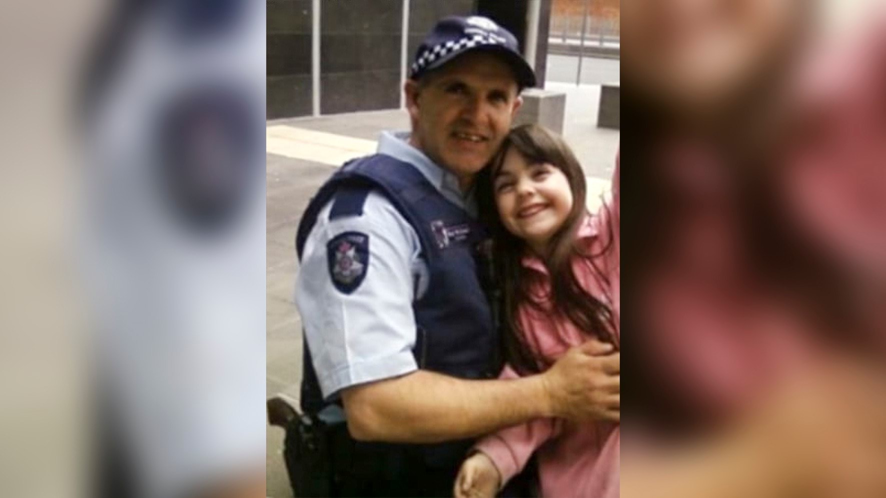 Male police officer holding young daughter