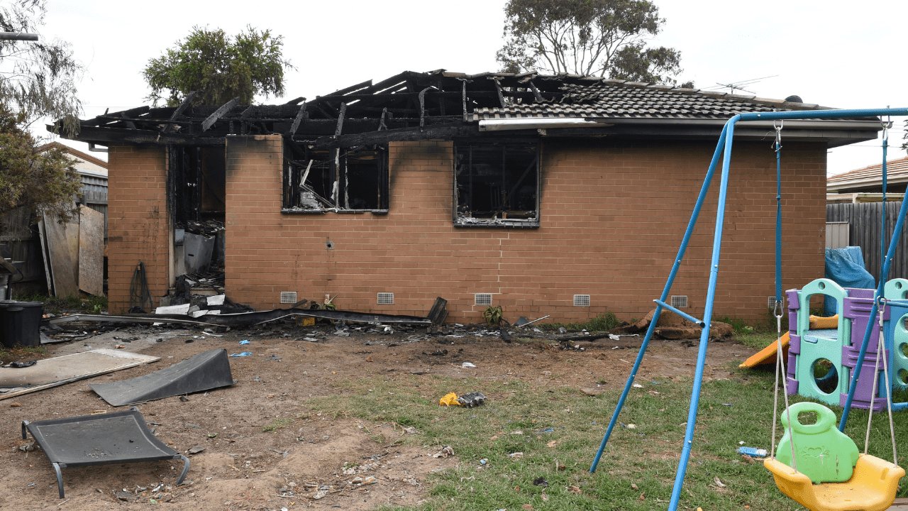 Police Life - an exterior photo of a brick home that has been destroyed by fire.