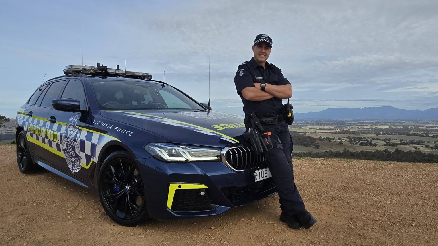 Northern Grampians Highway Patrol member Paul Santuccione standing in front of a highway patrol car