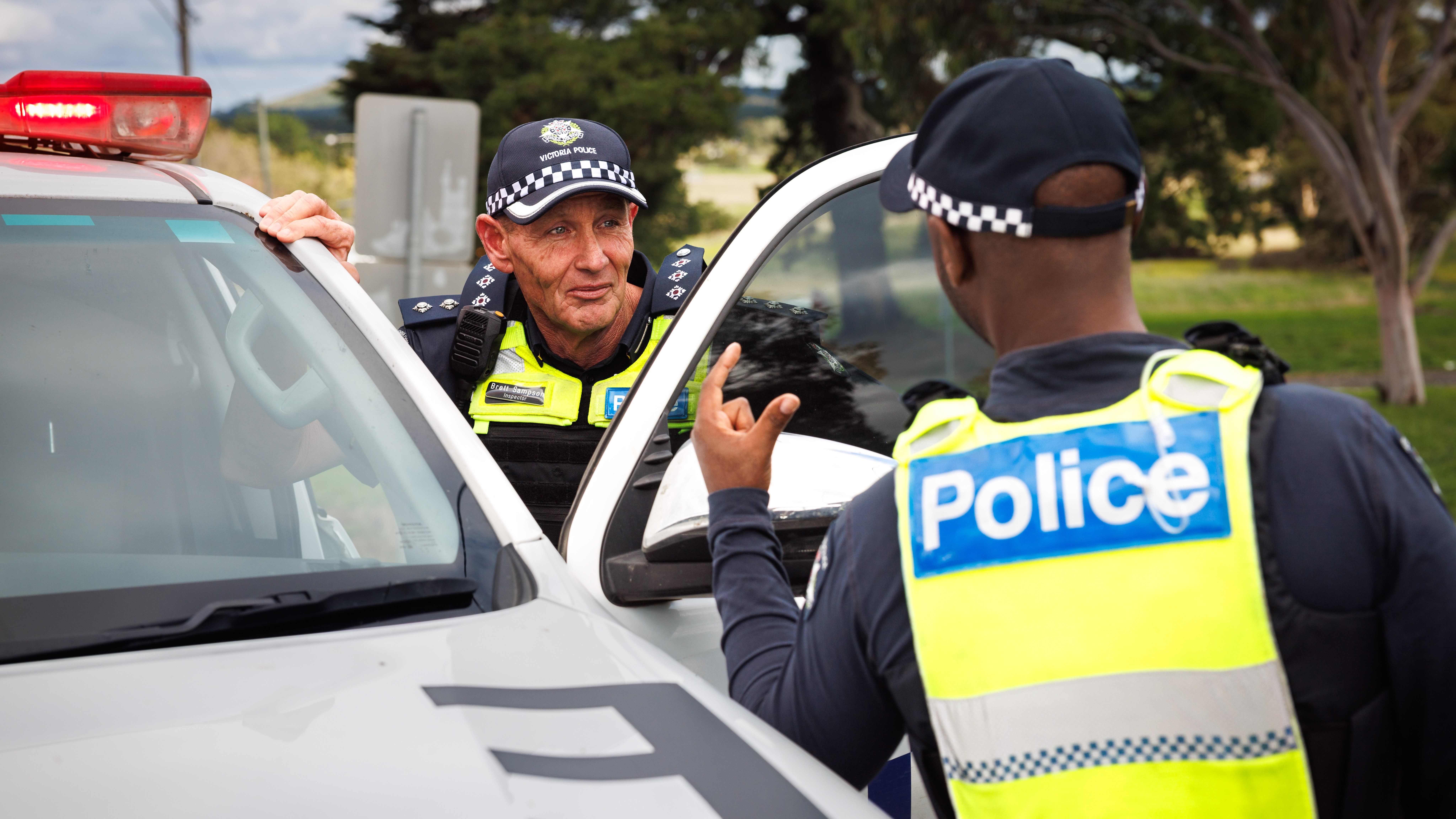 Two members talking as they get into a police vehicle