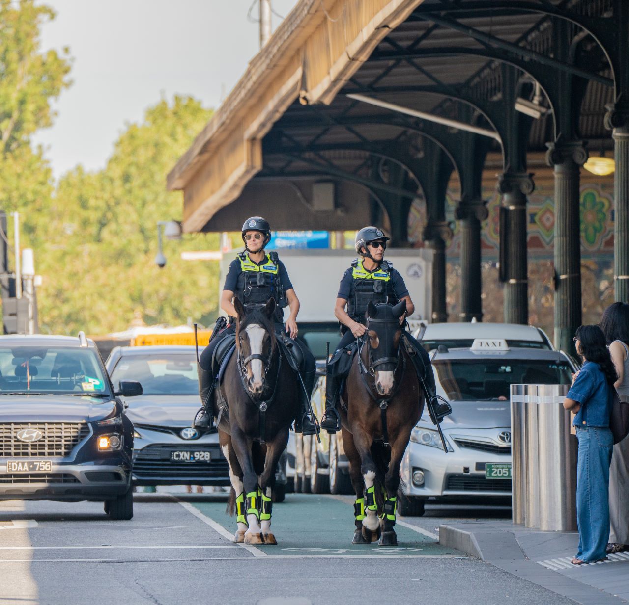 Two police officers on police horses, patrolling in the city. 