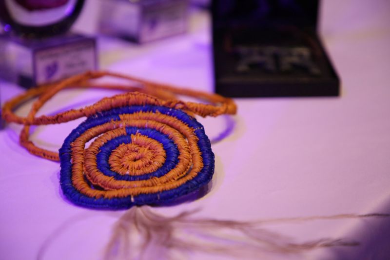 A blue and orange neck-piece, made with cloth, in a spiral shape. 