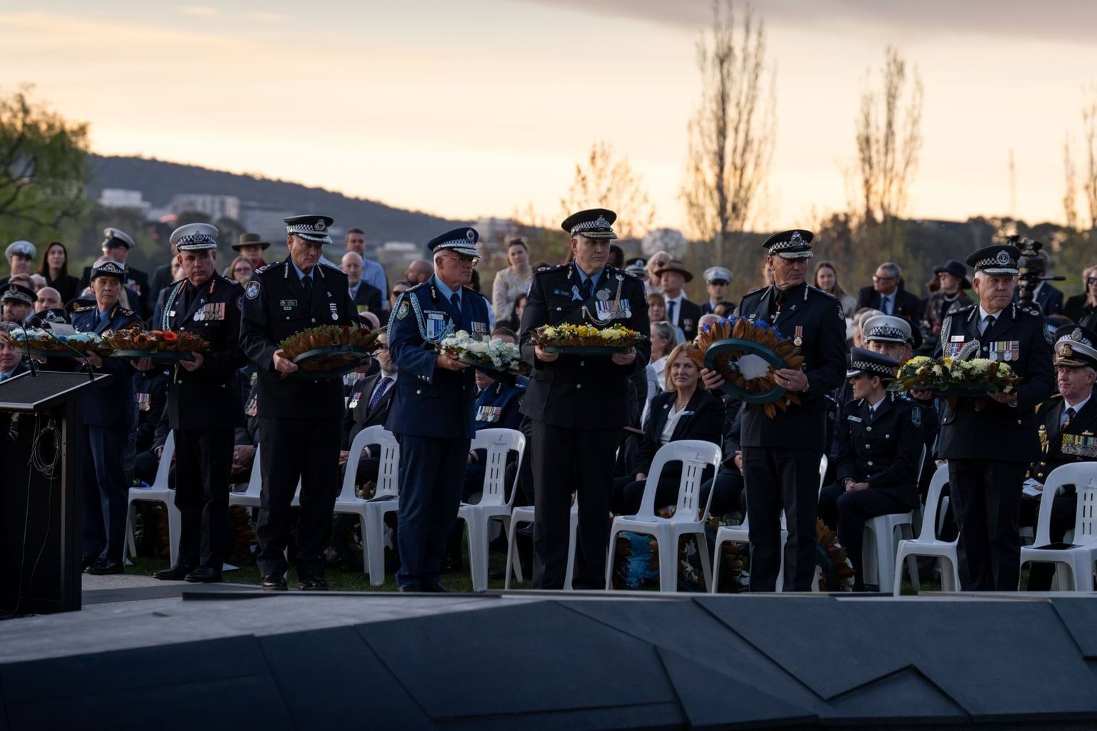 Image of police commissioners holding wreaths.