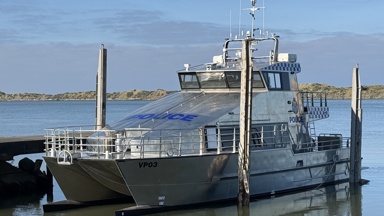 Police Life - silver police boat moored at jetty.