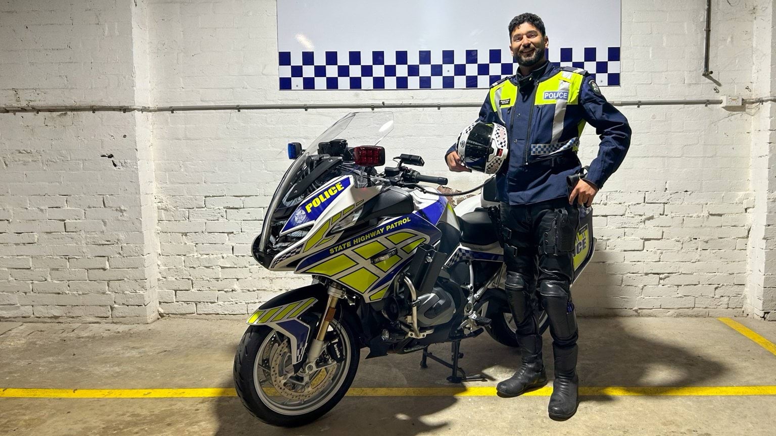 Member of the Solo Unit standing with a motorbike
